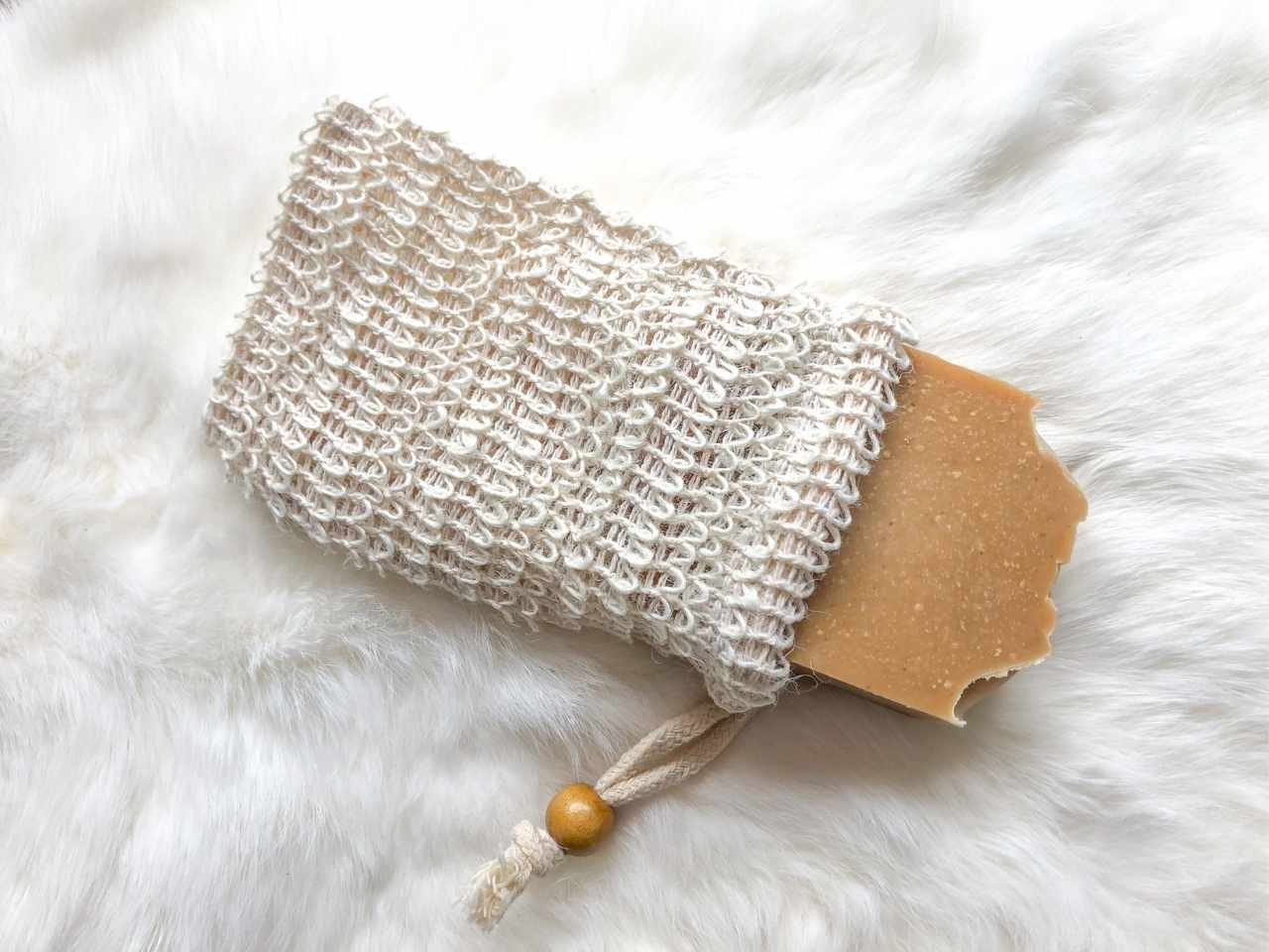 Soap saver bag with a soap bar inside on a white background.